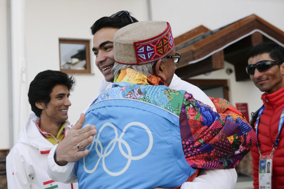 Indian luger Shiva Keshavan, center, facing camera, is hugged by supporter Omprakash Mundra after a welcome ceremony for the Indian Olympic team at the Mountain Olympic Village during the 2014 Winter Olympics, Sunday, Feb. 16, 2014, in Krasnaya Polyana, Russia. (AP Photo/Jae C. Hong)