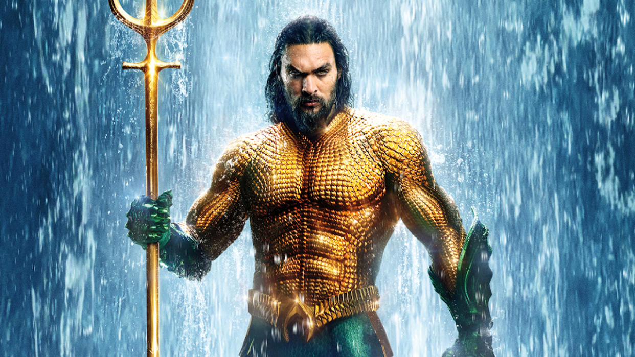  Aquaman in orange and green costume holding trident. 