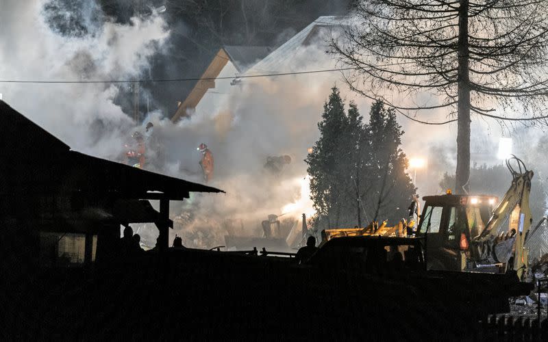 Firefighters work at the site of a building levelled by a gas explosion in Szczyrk,