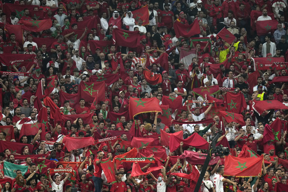 Morocco fans hold flags during the World Cup semifinal soccer match between France and Morocco at the Al Bayt Stadium in Al Khor, Qatar, Wednesday, Dec. 14, 2022. (AP Photo/Francisco Seco)