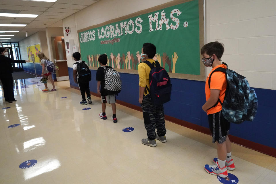 FILE - In this Sept. 3, 2020, file photo, students keep social distance as they walk to their classroom in Highwood, Ill., part of the North Shore school district. In response to a push for culturally responsive teaching that gained steam following last year's police killing of George Floyd, Republican lawmakers and governors have championed legislation to limit the teaching of material that explores how race and racism influence American politics, culture and law. The measures have become law in Tennessee, Idaho and Oklahoma and bills have been introduced in over a dozen other states. (AP Photo/Nam Y. Huh, File)