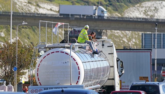 Protesters from Insulate Britain sit on top of a vehicle