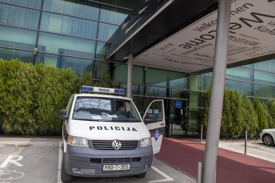 A police vehicle is parked in front of a hotel in Zenica, central Bosnia, Monday, April 20, 2020. Several dozen people in Bosnia are on a hunger strike to protest being quarantined in a hotel on suspicion they might be carrying the new coronavirus. The group of some 80 Bosnians work abroad and when they returned to the country they were placed under a 28-day quarantine in a hotel in the central town of Zenica. (AP Photo/Almir Alic)