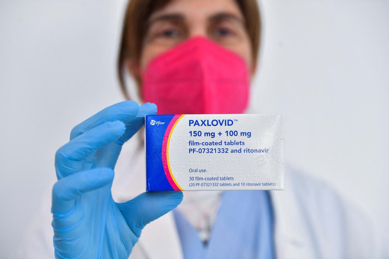 A doctor holds up a package of the antiviral drug Paxlovid