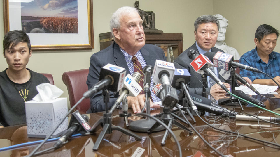 From left, Yingying Zhang's brother Zhengyang Zhang, Attorney Steve Beckett, Attorney Zhidong Wang, and Yingying's father Ronggao Zhang appear at a press conference at Beckett's law office on Wednesday, Aug. 7 2019 Urbana, Ill. The father of the slain scholar who begged his daughter's killer to reveal what he did with her remains so that they could be returned to China for burial says his family now understands that recovering them may be impossible. Ronggao Zhang said Wednesday that one of his lawyers explained that Brendt Christensen told his defense team he had divided Yingying Zhang's remains into three garbage bags that he threw into a dumpster before the dumpster's contents were compacted and buried in a landfill. (Robin Scholz/The News-Gazette via AP )