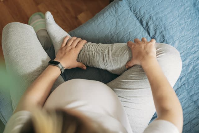 <p>Emilija Manevska / Getty Images</p> Massaging leg muscles