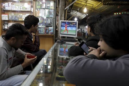 Men watch the Pakistan Super League (PSL) cricket match between Islamabad United and Peshawar Zalmi on a television at a shop in Rawalpindi, Pakistan, February 21, 2016. REUTERS/Faisal Mahmood