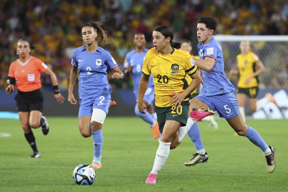 Australia's Sam Kerr, centre, challenges for the ball with France's Elisa De Almeida, right, and France's Maelle Lakrar during the Women's World Cup quarterfinal soccer match between Australia and France in Brisbane, Australia, Saturday, Aug. 12, 2023. (AP Photo/Tertius Pickard)