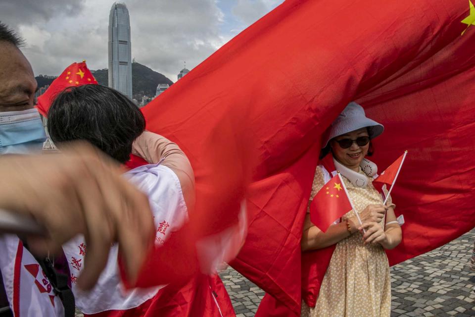 2023年7月1日，尖沙咀，市民在海傍手持國旗拍照。攝：陳焯煇/端傳媒