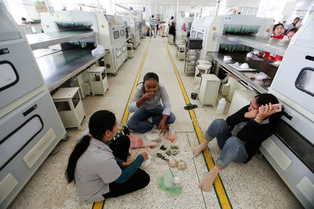 Women seat on the floor during their lunch break at Complete Honour Footwear Industrial, a footwear factory owned by a Taiwan company, in Kampong Speu, Cambodia, July 5, 2018. REUTERS/Ann Wang