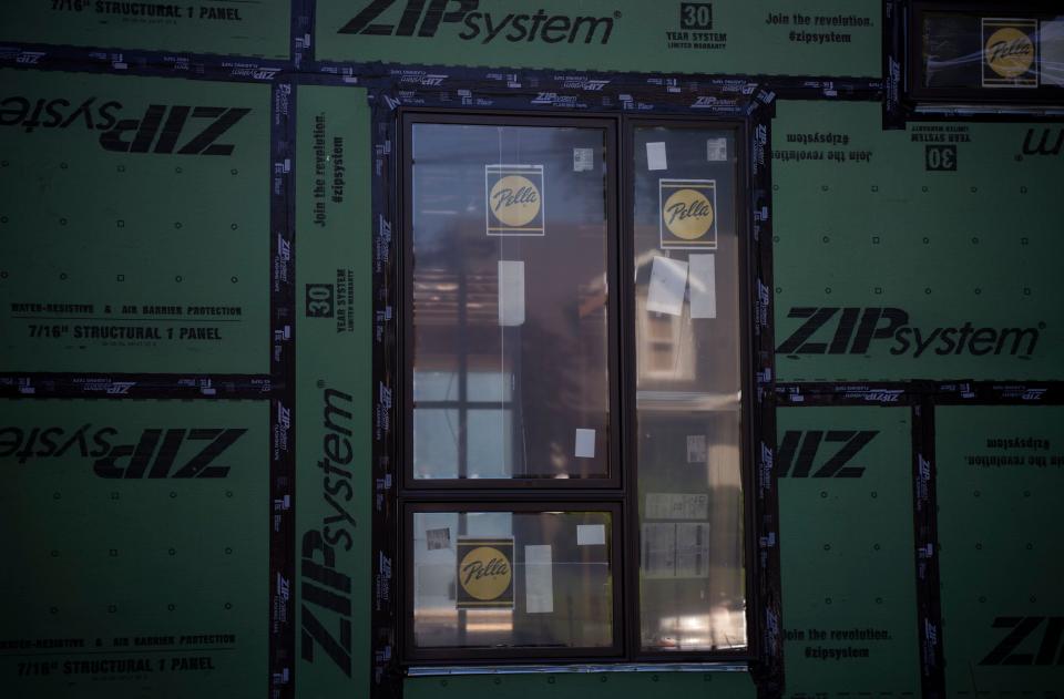 A home is reflected in the window of a new house that is being constructed on 5th Avenue in Salemtown in Nashville, Tenn., Thursday, May 9, 2024.