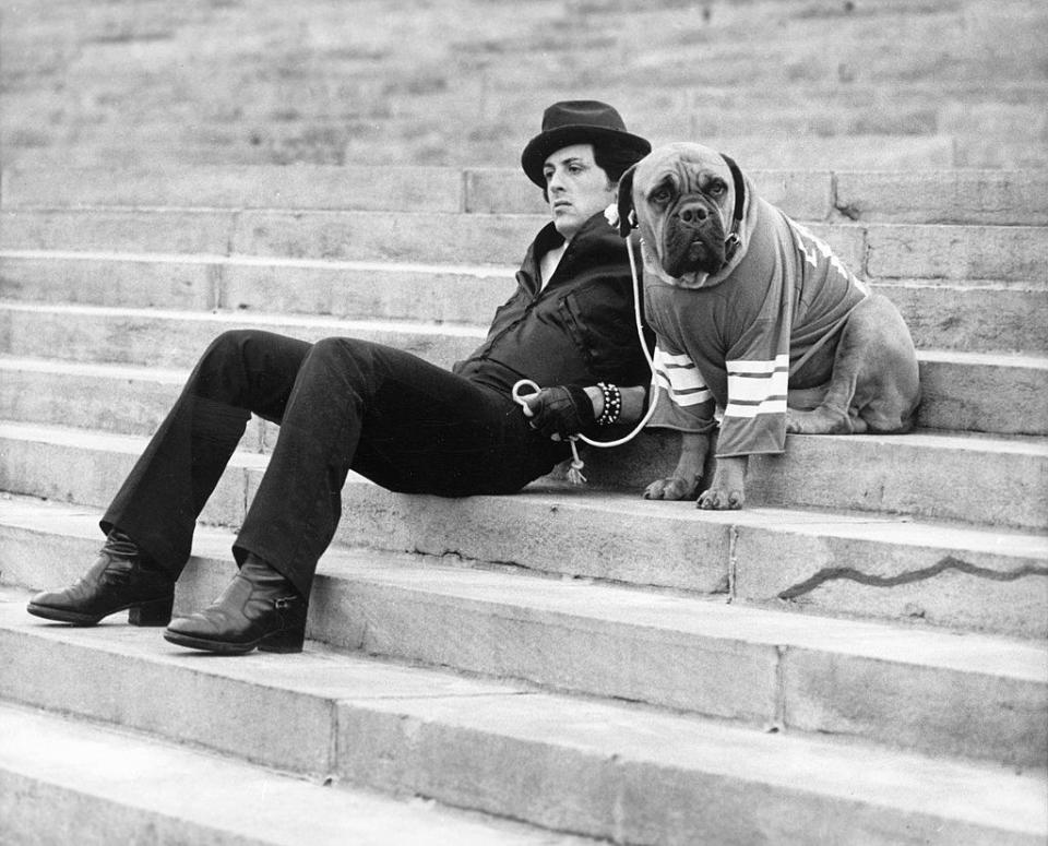 sylvester stallone sitting on thestairs with his dog