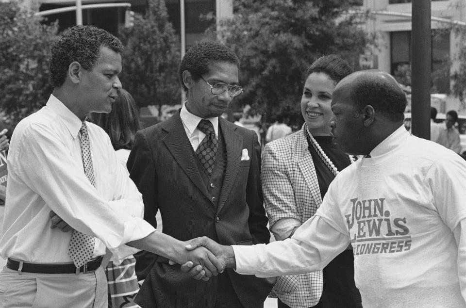 State Sen. Julian Bond greets Atlanta City Councilman John Lewis, right, during an election rally in downtown Atlanta, Monday, August 11, 1986 as former state Rep. Bobby Hill, center, looks on. Bond and Lewis are running for the U.S. 5th Congressional District seat vacated by Wyche Fowler, and Hill is running for Lt. Governor. (Photo: Ric Feld/AP)