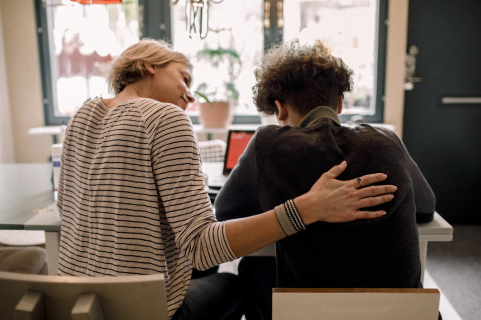 Mum comforting teenager at dinner table. Source: Getty Images