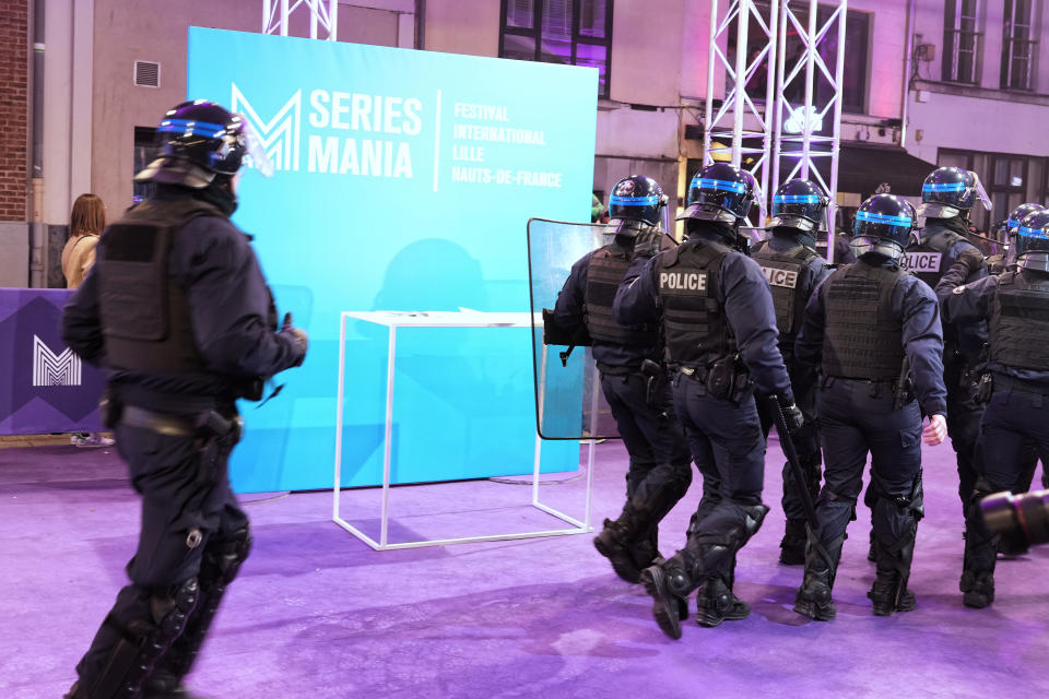 Riot police officers run onto the violet carpet of the festival to push back protesters against the pension reform in France as they try to invade the carpet of the Series Mania festival on March 21, 2023 in Lille, France