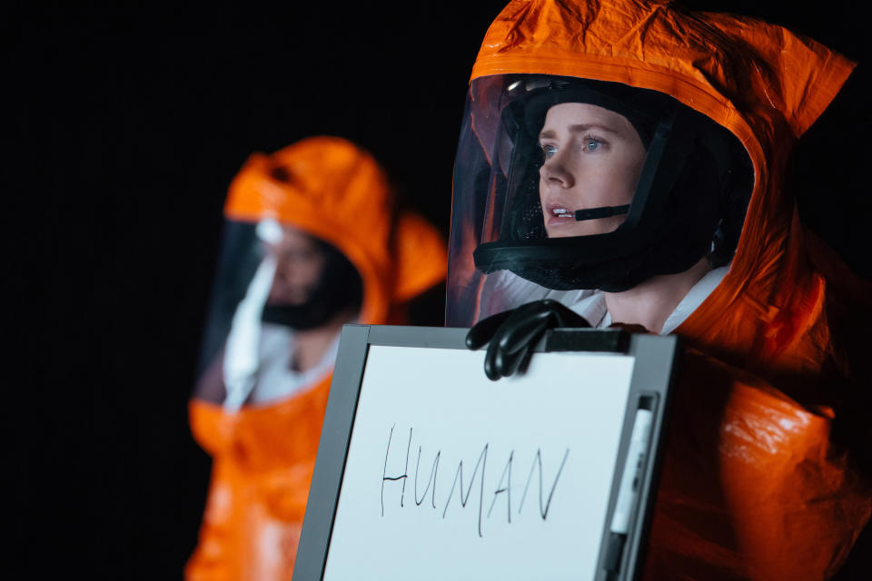 Amy Adams holding up a whiteboard that says 'HUMAN.'