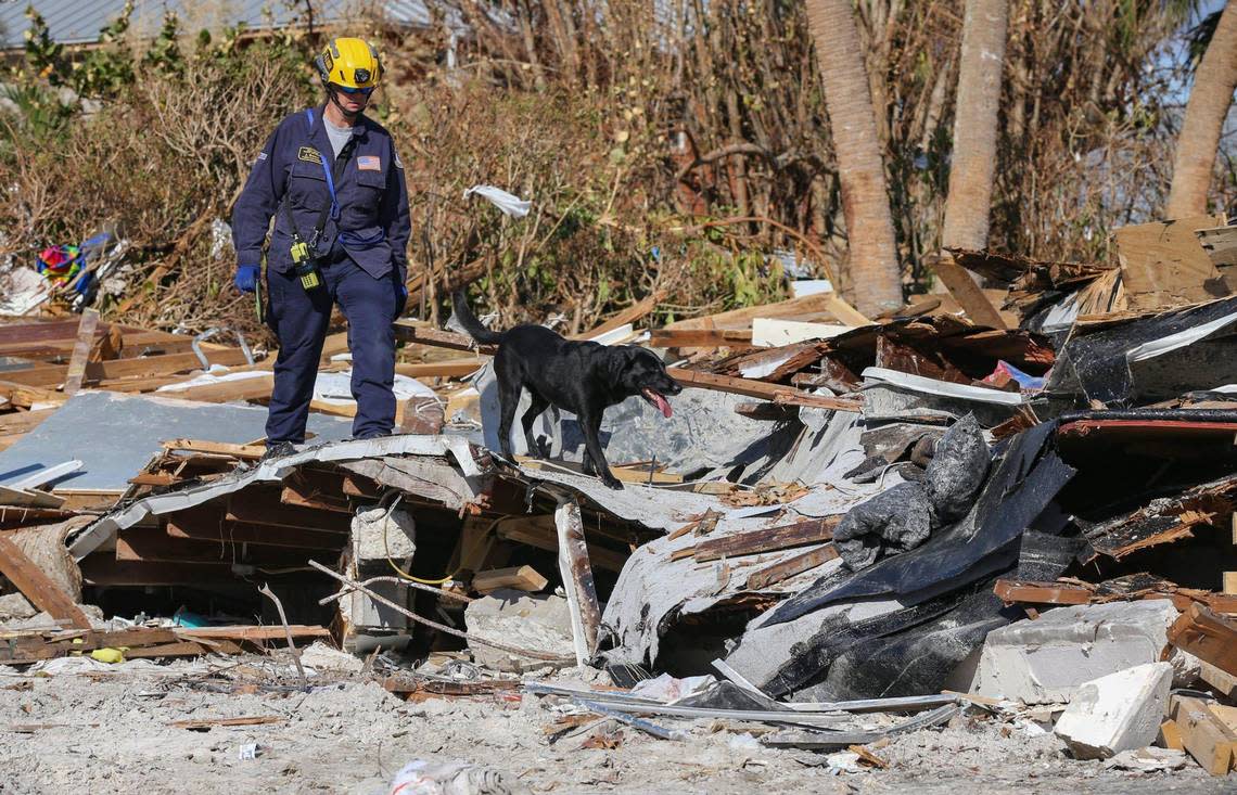 Urban Search and Rescue Florida Task Force 2 team member Jennifer Brown searches a damaged home with search and recovery dog Phame on Fort Myers Beach on Monday, Oct. 3, 2022.