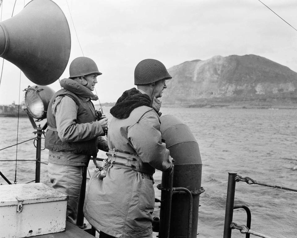 Secretary of the Navy James Forrestal, left, and Lt. Gen. Holland Smith, commander of Marines in the Pacific, watch the bitter fighting on Iwo Jima from a ship offshore Feb. 23, 1945.
