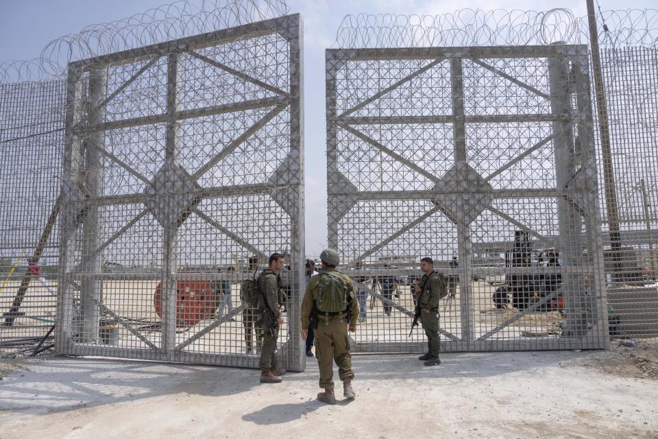 Israeli soldiers gather near a gate to walks through an inspection area for trucks carrying humanitarian aid supplies bound for the Gaza Strip, on the Israeli side of the Erez crossing into Gaza, Wednesday, May 1, 2024. (AP Photo/Ohad Zwigenberg)