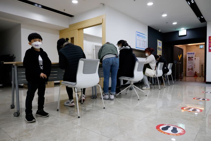 People fill in a mandatory document to get an influenza vaccine at a branch of the Korea Association of Health Promotion in Seoul