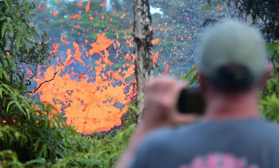 A man watches as lava&nbsp;spews from a fissure in Leilani Estates on Friday.