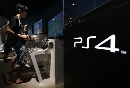 A man plays a video game on Sony Corp's PlayStation 4 console at its showroom in Tokyo July 16, 2014. REUTERS/Yuya Shino