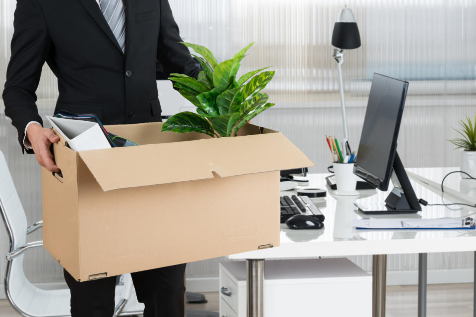 Man clearing out desk and taking the potted plant