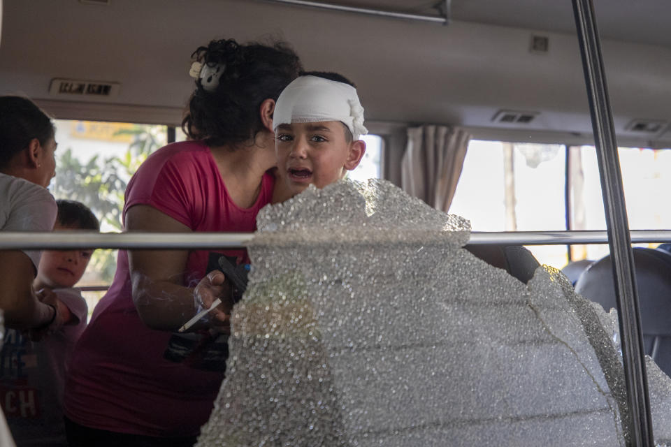 A Syrian boy cries in front of shattered glass after the bus was attacked by members of the Christian rightwing Lebanese Forces group who threw stones at the bus carrying Syrians to vote at the Syrian Embassy in the town of Zouk Mosbeh, north of Beirut, Lebanon, Thursday, May 20, 2021. Mobs of angry Lebanese men attacked vehicles carrying Syrians expatriates and those who fled the war heading to the Syrian embassy in Beirut on Thursday, protesting against what they said was an organized vote for President Bashar Assad. (AP Photo/Hassan Ammar)