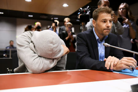 The 18-year-old Moroccan Mohamed Bakier, (L) covers his face during the initial remand hearing of suspects of killing two people and attempting to kill eight others with terrorist intent in Turku last week, at the Southwest Finland District Court in Turku, Finland, August 22, 2017. LEHTIKUVA / Martti Kainulainen via REUTERS