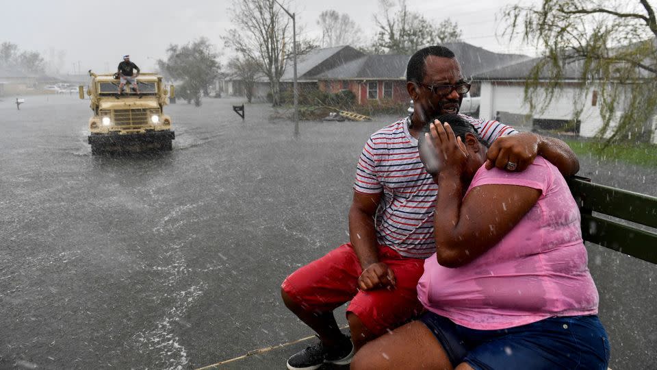 People are soaked by rain from Hurricane Ida while evacuating out of a flooded neighborhood in a high water truck after neighborhoods flooded in LaPlace, Louisiana, on August 30, 2021. - Patrick T. Fallon/AFP/Getty Images