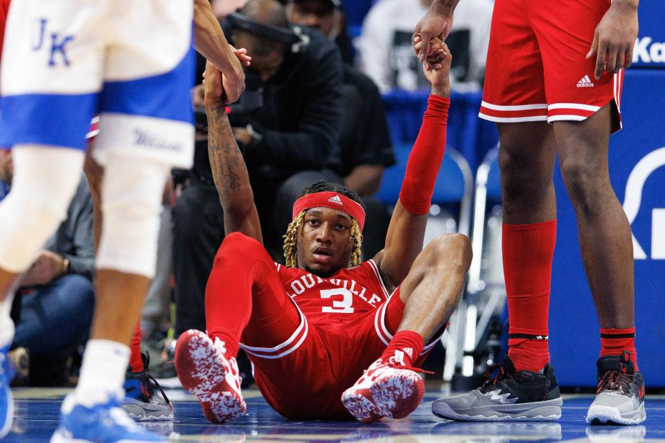 Dec 31, 2022; Lexington, Kentucky, USA; Louisville Cardinals guard El Ellis (3) is helped to his feet by teammates during the second half against the Kentucky Wildcats at Rupp Arena at Central Bank Center. Mandatory Credit: Jordan Prather-USA TODAY Sports