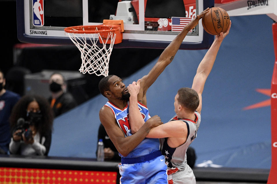 Brooklyn Nets forward Kevin Durant, left, fouls Washington Wizards center Moritz Wagner, right, during the second half of an NBA basketball game, Sunday, Jan. 31, 2021, in Washington. (AP Photo/Nick Wass)