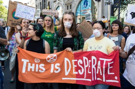 People demonstrate during an Extinction Rebellion protest outside the Brazilian embassy in London