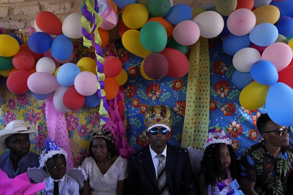 Adonildes da Cunha, right, Emperor, and Nilda dos Santos, left, Queen, arrive for a celebration after Mass in the chapel of the Kalunga quilombo, during the culmination of the week-long pilgrimage and celebration for the patron saint "Nossa Senhora da Abadia" or Our Lady of Abadia, in the rural area of Cavalcante in Goias state, Brazil, Monday, Aug. 15, 2022. Devotees, who are the descendants of runaway slaves, celebrate Our Lady of Abadia at this time of the year with weddings, baptisms and by crowning distinguished community members, as they maintain cultural practices originating from Africa that mix with Catholic traditions. (AP Photo/Eraldo Peres)
