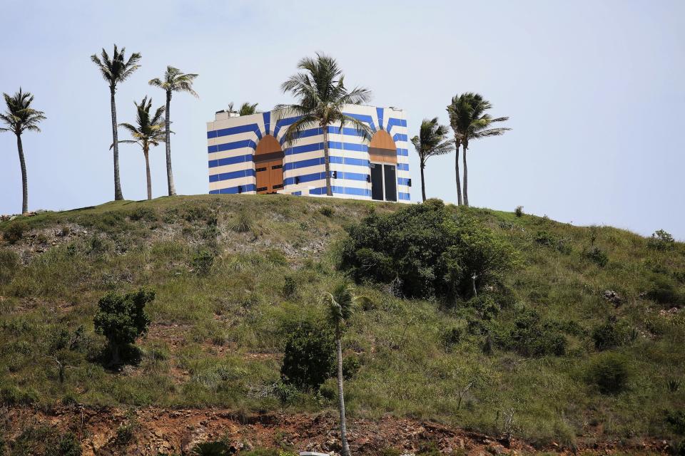 A blue-striped structure sits on a lookout point on Little St. James Island, in the U. S. Virgin Islands, a property owned by Jeffrey Epstein, Wednesday, Aug. 14, 2019. Epstein bought Little St. James Island more than two decades ago and built a stone mansion with cream-colored walls on one end of it. Surrounding it are several other structures including the maids’ quarters and the huge, square-shaped, blue-striped building on the other end of the island that workers told each other was a music room fitted with a grand piano and acoustic walls. (AP Photo/Gabriel Lopez Albarran)