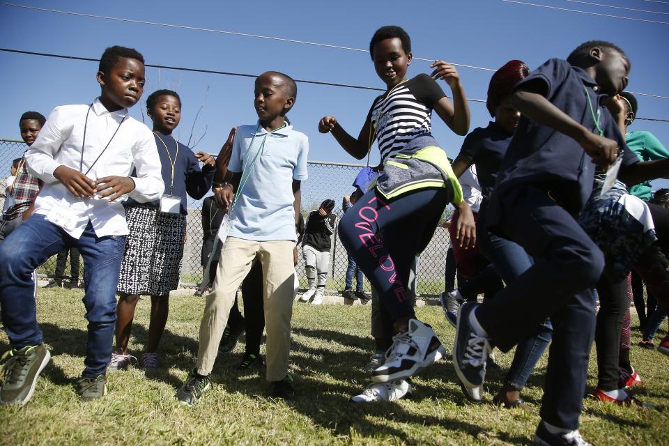 From left to right, students Malic Nyongolo, Asende Lubuku, Buruhan Ahmed, Diane Nyiranduhura, and Abantaki Alonda all dance to music at Valencia Newcomer School Thursday, Oct. 17, 2019, in Phoenix. Children from around the world are learning the English skills and American classroom customs they need to succeed at so-called newcomer schools. Valencia Newcomer School in Phoenix is among a handful of such public schools in the United States dedicated exclusively to helping some of the thousands of children who arrive in the country annually. (AP Photo/Ross D. Franklin)