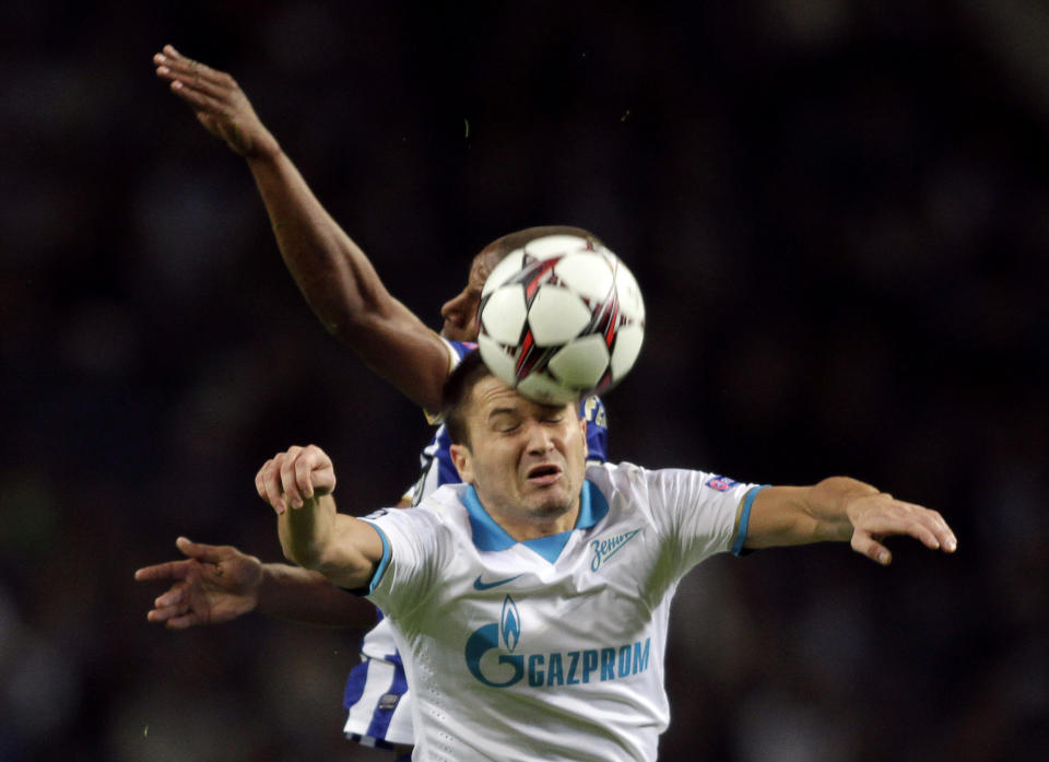 Porto's Fernando Reges (back) jumps for the ball with Zenit St Petersburg's Viktor Fayzulin during their Champions League soccer match at Dragon stadium in Porto October 22, 2013. REUTERS/Miguel Vidal (PORTUGAL - Tags: SPORT SOCCER)