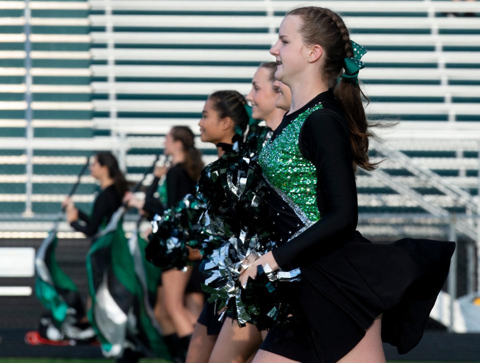 Aurora's dance team crosses the field during its pregame performance on Friday.