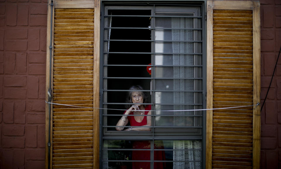 Carmela Corleto poses for a portrait inside her home where she lives alone and waits her turn to get a COVID-19 vaccine in Burzaco, Argentina, Thursday, Feb. 18, 2021. Corleto, who says she has carried out strict isolation to avoid getting COVID-19 and sees it more as a goal than a burden, got her first shot of the AstraZeneca vaccine on April 23, 2021. (AP Photo/Natacha Pisarenko)