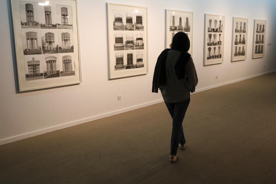 A visitor looks at artworks by German artists Bernd and Hilla Becher while visiting a 19th and 20th-century American and European minimalist and conceptual masterpieces show at the Tehran Museum of Contemporary Art in Tehran, Iran, Tuesday, Aug. 2, 2022. Some of the world’s most prized works of contemporary Western art have been unveiled for the first time in decades — in Tehran. (AP Photo/Vahid Salemi)