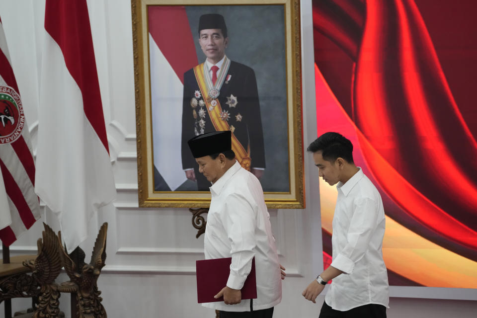 Indonesian Defense Minister and president-elect Prabowo Subianto, left, walks with his running mate Gibran Rakabuming Raka, the eldest son of Indonesian President Joko Widodo past a portrait of Widodo during their formal declaration as president and vice president-elect at the General Election Commission building in Jakarta, Indonesia, Wednesday, April 24, 2024. Indonesia's electoral commission formally Subianto as the elected president in a ceremony on Wednesday after the country's highest court rejected appeals lodged by two losing presidential candidates who are challenging his landslide victory. (AP Photo/Dita Alangkara)