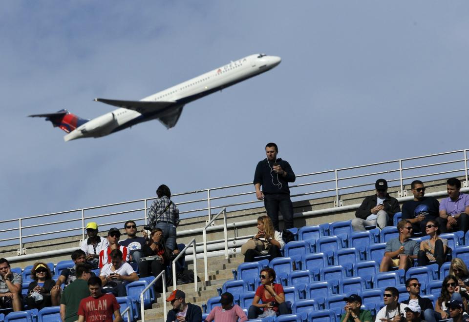 An airliner takes off from nearby LaGuardia Airport as spectators watch as Nadal of Spain faces Djokovic of Serbia in the men's final match at the U.S. Open tennis championships in New York