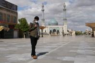 A man wearing a protective face mask, following the outbreak of coronavirus disease (COVID-19), walks on the street in Qom