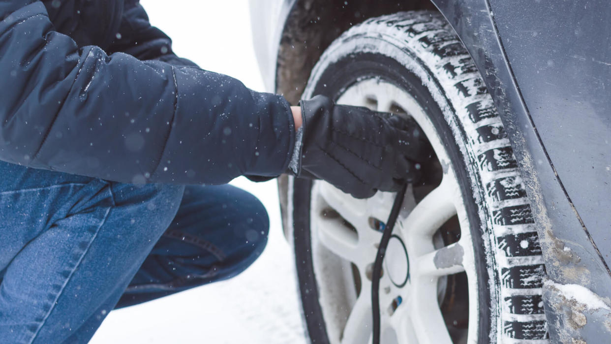 man inflating winter tires