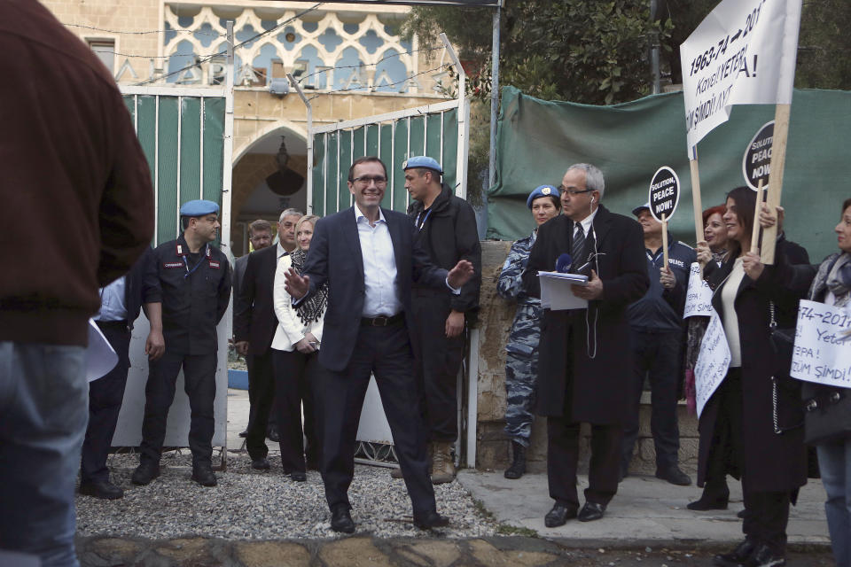 U.N. Special Advisor of the Secretary-General Espen Barth Eide, center, addresses protesters outside the main gate of Ledras Palace, where a dinner for ethnically divided Cyprus' rival leaders will be held, inside the U.N buffer zone in the divided capital Nicosia, Cyprus, Sunday, April 2, 2017. A United Nations-hosted dinner for the two leaders aims to clinch a swift restart of talks that broke down in February amid a squabble over Cyprus' troubled history. (AP Photo/Petros Karadjias)