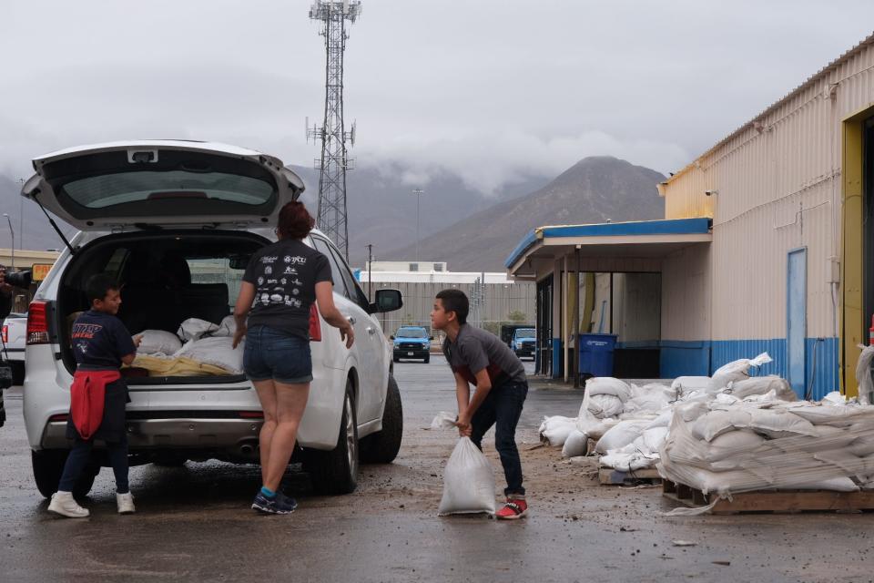 Julian Baez, from left, Alicia Rodriguez, center, and Joshua Baez, right, load sandbags at the El Paso Water Northeast Stormwater Operations Center Tuesday, June 29, 2021, in El Paso.