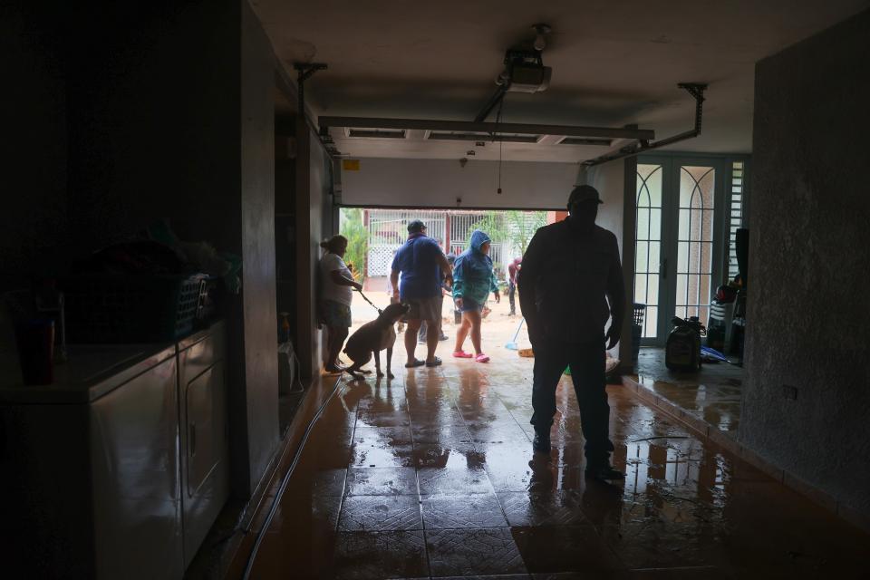People clean a house flooded by the rains of Hurricane Fiona (AP)