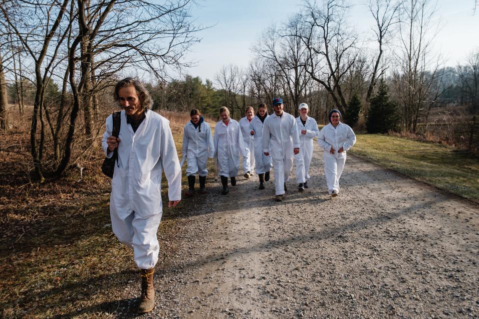 New Philadelphia High School science teacher Kip Brady, left, leads students along a road on the way to locations targeted for the collection of ticks at the Norma Johnson Center in Dover Township. The insects would be taken back to the classroom for further study of the bacteria known to cause Lyme disease.