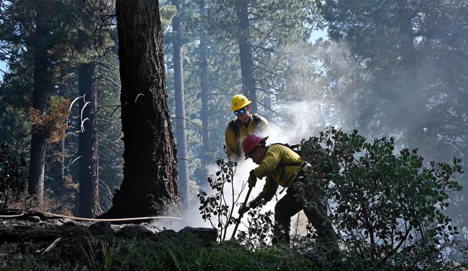 Eldorado National Forest Firefighters Cai Phuong, front, and Alex Stanfield mop up hotspots after a prescribed burn in the Stanislaus National Forest in Calif., on Friday, May 20, 2022.