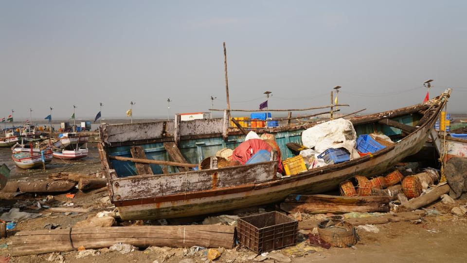 Boats damaged by previous cyclones sit near the dock, in northern Mumbai's Madh island area, serving as a reminder of the effects of warming ocean temperatures on this small community. 